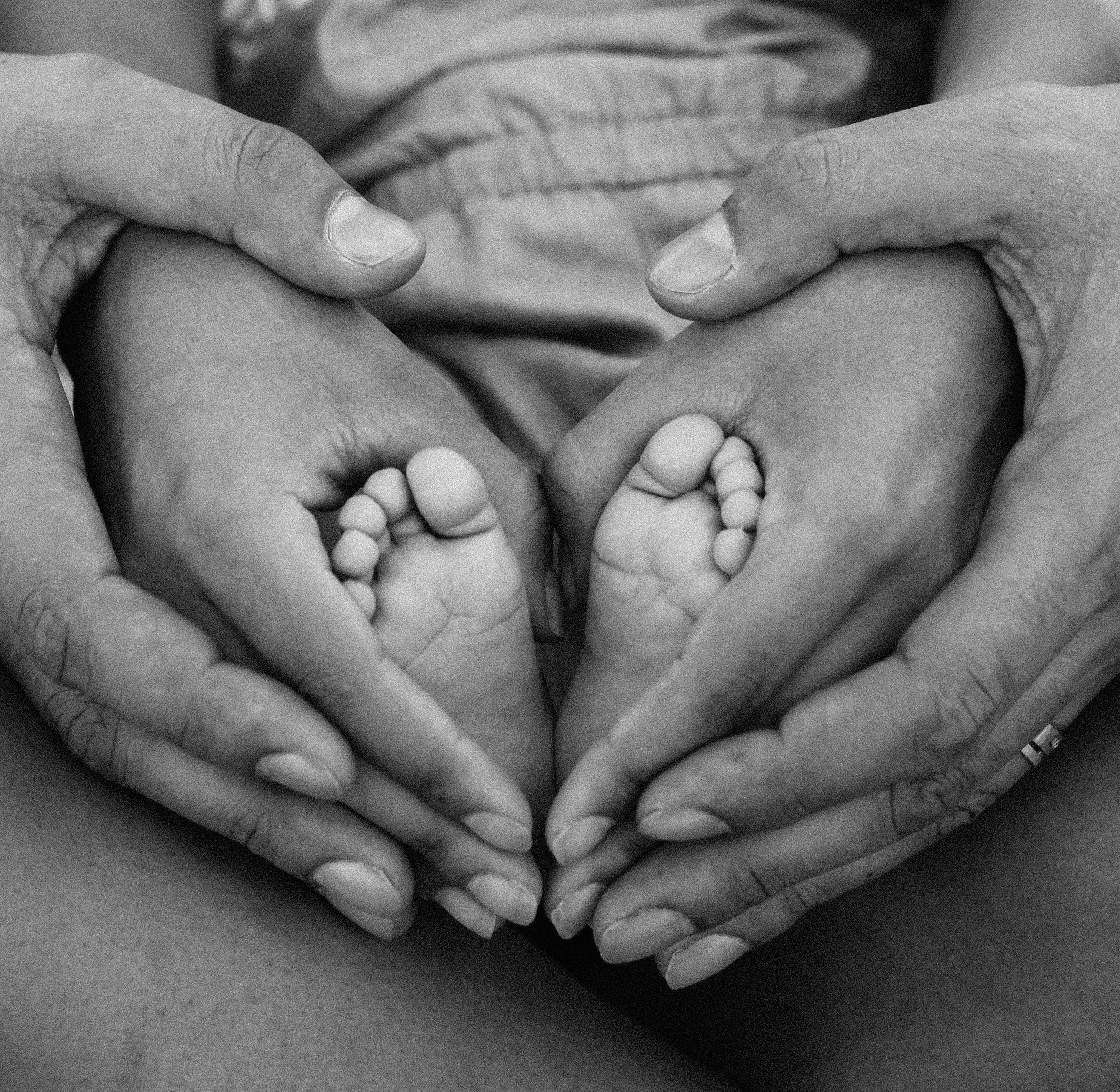 Parents' hands holding a baby’s feet